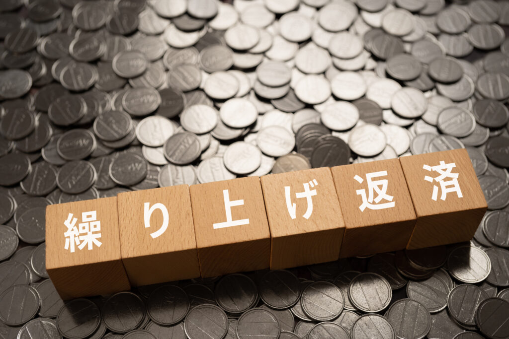 ⑥ 繰り上げ返済と書かれたブロックとコイン