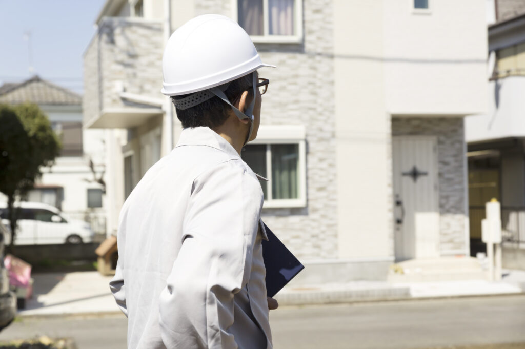 住宅とヘルメットの男性