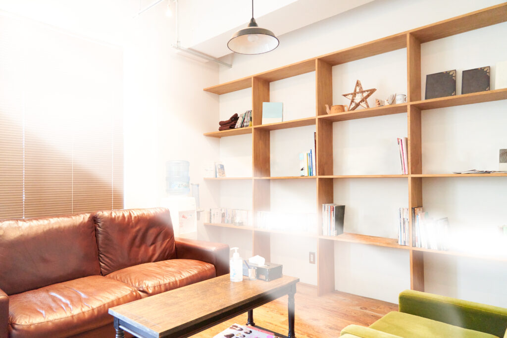 ソファーとオープンシェルフのある室内　待合